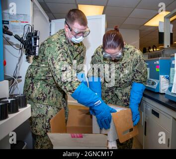 PORTSMOUTH, Virginia (dic. 15, 2020) Ospedale Corpsman III Classe Karsten Foster, a sinistra, e Ospedale Corpsman III Classe Hannah può scaricare una spedizione di vaccini COVID-19 in un congelatore al Naval Medical Center Portsmouth, 15 dicembre 2020. Le vaccinazioni per il personale sanitario inizieranno il 16 dicembre. NMC Portsmouth è una delle prime strutture di trattamento militare del Dipartimento della Difesa a ricevere il vaccino COVID-19. (STATI UNITI Foto Navy di Mass Communication Specialist 2a classe Dylan M. Kinee) 201215-N-MT837-1007 Foto Stock