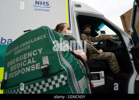 Servizio di ambulanza Scozzese Paramedic Amy Young a fianco di Guy Spiers privati dal 68 Squadron del 7° Regiment Royal Logistic Corps durante una visita del Segretario della Sanità Humza Yousaf (non raffigurata) al centro di educazione clinica nell'edificio Scottish Fire and Rescue di Hamilton, Lanarkshire, Dove ha incontrato il personale dell'esercito per ringraziarli per aver aiutato il Servizio di ambulanza Scozzese. Data foto: Venerdì 24 settembre 2021. Foto Stock