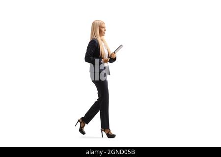 Scatto a tutto profilo di una giovane donna professionista in abito e tacchi alti che camminano isolati su sfondo bianco Foto Stock