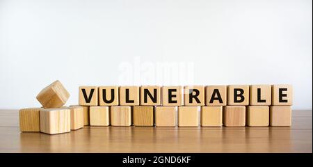Simbolo vulnerabile. La parola vulnerabile sui cubi di legno. Bella tavola di legno, sfondo bianco. Business e concetto vulnerabile. Spazio di copia. Foto Stock