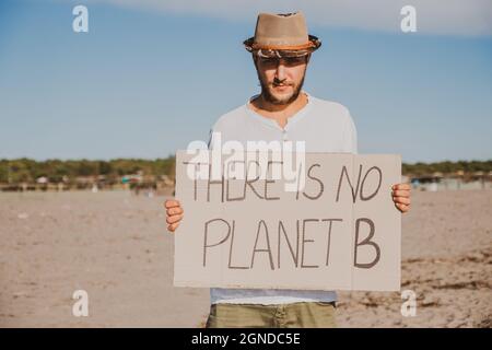 Attivista raccolta rifiuti di plastica sulla spiaggia. Persone che puliscono la spiaggia, con borse. Concetto di conservazione ambientale e di inquinamento oceanico prolile Foto Stock