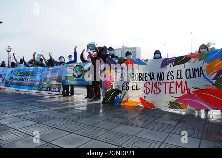 Lima, Perù. 24 settembre 2021. Gruppo di dimostranti con una bandiera che dice "il problema non è il clima, è il sistema" quando decine di attivisti svolgono una manifestazione di fronte al Palazzo giudiziario peruviano, come parte dello sciopero Globale sul clima chiamato da venerdì per il futuro, per chiedere immediato, Azione concreta e ambiziosa in risposta all'attuale crisi climatica credito: Fotoholica Press Agency/Alamy Live News Foto Stock