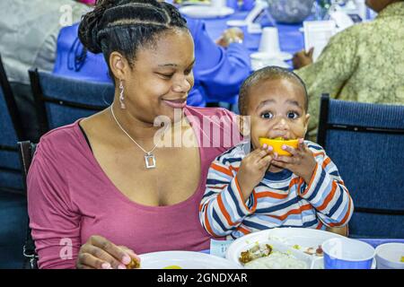 Miami Gardens Florida, nonni che alzano i nipoti apprezzare la colazione, famiglia bambino Black madre figlio mangia arancione Foto Stock