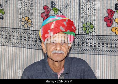 Primo piano ritratto di un anziano indiano che indossa un turbano colorato secondo il costume , tradizionale e religione e sorridendo alla macchina fotografica Foto Stock
