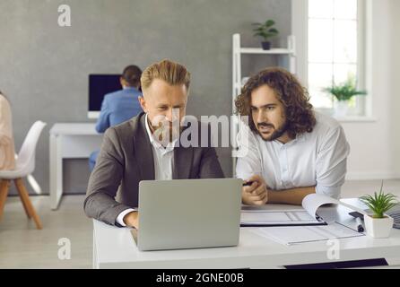 Dipendenti motivati e diversi lavorano insieme online sul computer Foto Stock