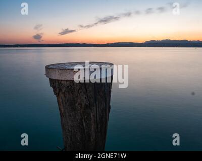 Tramonto sul Lago di Garda con il Polo di ormeggio a Sirmione, Lombardia, Italia in estate Foto Stock