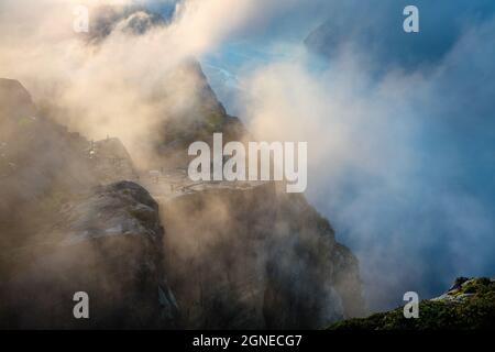 Molti turisti sul bordo della scogliera, popolare attrazione norvegese Preikestolen. Nebbia d'estate mattina vista del fiordo di Lysefjorden, situato nel Ryfy Foto Stock