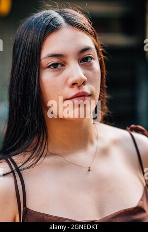 primo piano verticale ritratto di una giovane donna cinese attraente guardando la macchina fotografica Foto Stock