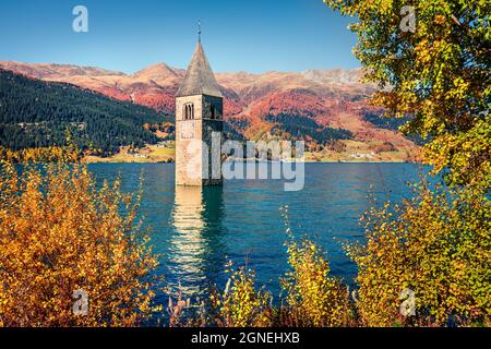 Bella vista autunnale della torre della chiesa sunken nel lago di Resia. Incredibile scena mattutina delle Alpi italiane, Alto Adige, Italia, Europa. Concetto di viaggio backgro Foto Stock