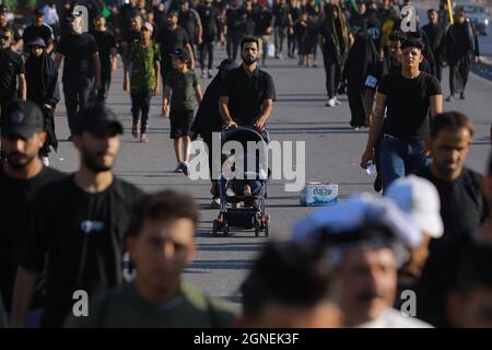 Baghdad, Iraq. 25 Settembre 2021. I musulmani sciiti marciano da Baghdad per visitare la Moschea Husayn a Karbala in occasione di Arba'een, nota anche come Chehelom, un'osservanza religiosa che avviene quaranta giorni dopo il giorno di Ashura per commemorare il martirio di Husayn ibn Ali, nipote del profeta islamico Muhammad, Che è stato ucciso il 10° giorno del mese di Muharram, secondo il calendario islamico. Credit: Ameer al Mohammedaw/dpa/Alamy Live News Foto Stock