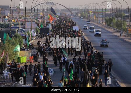 Baghdad, Iraq. 25 Settembre 2021. I musulmani sciiti marciano da Baghdad per visitare la Moschea Husayn a Karbala in occasione di Arba'een, nota anche come Chehelom, un'osservanza religiosa che avviene quaranta giorni dopo il giorno di Ashura per commemorare il martirio di Husayn ibn Ali, nipote del profeta islamico Muhammad, Che è stato ucciso il 10° giorno del mese di Muharram, secondo il calendario islamico. Credit: Ameer al Mohammedaw/dpa/Alamy Live News Foto Stock