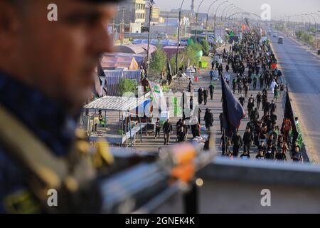 Baghdad, Iraq. 25 Settembre 2021. I musulmani sciiti marciano da Baghdad per visitare la Moschea Husayn a Karbala in occasione di Arba'een, nota anche come Chehelom, un'osservanza religiosa che avviene quaranta giorni dopo il giorno di Ashura per commemorare il martirio di Husayn ibn Ali, nipote del profeta islamico Muhammad, Che è stato ucciso il 10° giorno del mese di Muharram, secondo il calendario islamico. Credit: Ameer al Mohammedaw/dpa/Alamy Live News Foto Stock