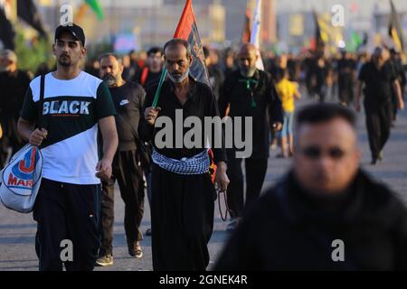 Baghdad, Iraq. 25 Settembre 2021. I musulmani sciiti marciano da Baghdad per visitare la Moschea Husayn a Karbala in occasione di Arba'een, nota anche come Chehelom, un'osservanza religiosa che avviene quaranta giorni dopo il giorno di Ashura per commemorare il martirio di Husayn ibn Ali, nipote del profeta islamico Muhammad, Che è stato ucciso il 10° giorno del mese di Muharram, secondo il calendario islamico. Credit: Ameer al Mohammedaw/dpa/Alamy Live News Foto Stock