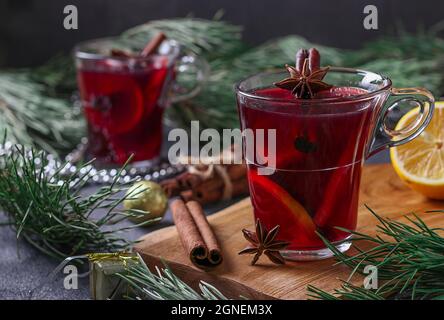 VIN brulé di Natale in due bicchieri di vetro su un asse di legno su sfondo grigio scuro Foto Stock