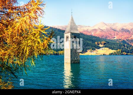 Affascinante vista autunnale del campanile della chiesa di Curon Venosta che sorge dalle acque del lago di Resia, villaggio di Graun im Vinschgau, Trentino-Alto Adige Foto Stock