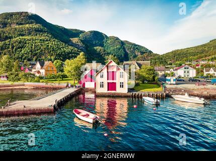 Attraente vista estiva del tipico villaggio norvegese Jondal, sulla riva del fiordo. Sole mattina panorama di campagna, Norvegia, Europa. Viaggiando co Foto Stock