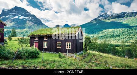 Casa in legno con tetto in erba tipico norvegese sul lago Innerdalsvatna. Scena mattutina di sole della Norvegia, Europa. Bellezza del concetto di campagna sfondo. Foto Stock