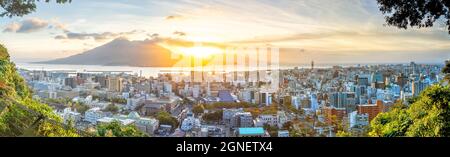 Kagoshima città skyline città centro città con il vulcano Sakurajima a Kyushu, Giappone all'alba Foto Stock