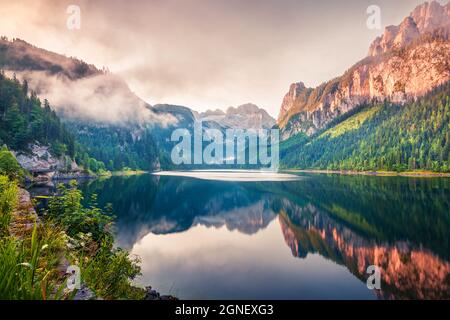 Perfetta alba estiva sul lago Vorderer (Gosausee) con il ghiacciaio Dachstein sullo sfondo. Vista mistica mattutina delle Alpi austriache, alta Austria, Euro Foto Stock