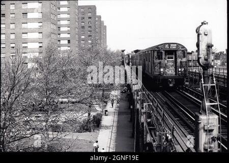 Il treno sopraelevato IRT numero 2 ha diretto Uptown e cavalcando le case di appartamenti nel Bronx, New York. Circa 1977. Foto Stock