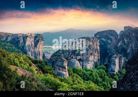 Vista maestosa dei famosi monasteri ortodossi orientali elencati come sito Patrimonio Mondiale dell'Umanita', costruiti sulla cima di colonne di roccia. Splendido tramonto primaverile di Kalabaka Foto Stock