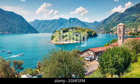 Bella giornata di sole sul lago di Como. Luminoso panorama mattutino dell'isola di Comocina dall'abitato di Ossuccio, provincia di Como, regione Lombardia, Italia, Europ Foto Stock