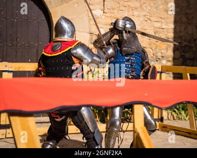 cavalieri medievali in duello, cavaliere blu che attacca il torneo di profight nel castello di montonis lleida catalogna spagna Foto Stock