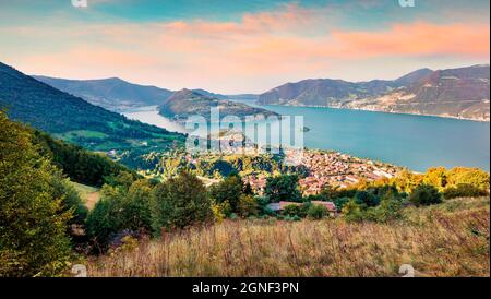 Vista aerea estiva del lago d'Iseo. Colorato paesaggio urbano mattutino della città di Marone con l'isola di Monte Isola, provincia di Brescia, Italia, Europa. Conc. In viaggio Foto Stock