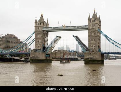La barca a vela galleggerà attraverso un Tower Bridge aperto in una giornata nuvolosa. Londra - 25 settembre 2021 Foto Stock