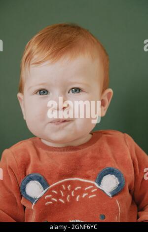 Una bambina dai capelli rossi di sette mesi Foto Stock