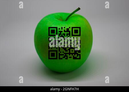 Una mela verde con codice QR. Sfondo bianco. Spazio di testo. Foto Stock