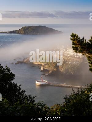 Nebbia di mattina presto sopra il molo di Banjo e la Cornovaglia di Looe Island Foto Stock