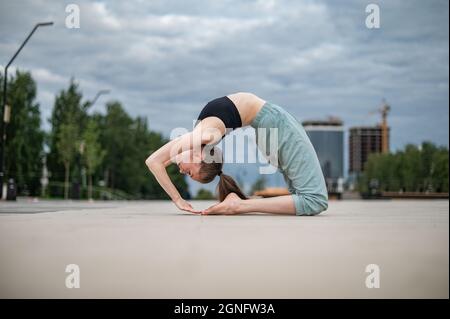 La ragazza pratica yoga e meditazione in città. Foto Stock