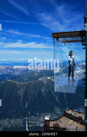 Chamonix, Francia - 10 luglio 2021. Tourist si trova nella scatola di vetro 'Step into the Void' sulla cima della montagna Aiguille Du Midi (3842m) sopra Chamonix Foto Stock