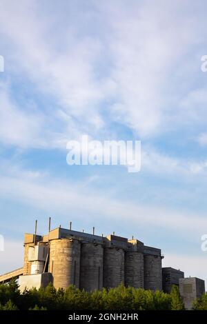 Silos di calcestruzzo per materiali sciolti contro il cielo nuvoloso. Foto scattata in buone condizioni di illuminazione Foto Stock