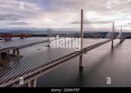 North Queensferry, Eaglesham, Scozia, Regno Unito. 25 Settembre 2021. NELLA FOTO: Vista aerea con droni dei ponti Forth. Lungo tre secoli di progettazione di ponti e collegando due delle contee scozzesi di Fife e Lothian, il ponte più recente del Queensferry Crossing Scotland progettato per assomigliarsi a vele su una nave, collega North Queensferry a South Queensferry, Con Forth Road Bridge dietro che mostra la tecnologia della metà del XX secolo e sfondo Forth Rail Bridge fine 1800 con la sua costruzione a sbalzo. Credit: Colin Fisher/Alamy Live News Foto Stock