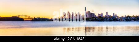 Moderna città globale di Sydney riflessgn in acque ferme del fiume Parramatta e del porto in soft luce del mattino - ampio panorama. Foto Stock