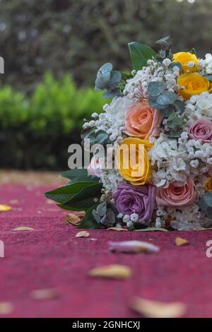 Un colpo verticale del bouquet della sposa a terra in un parco Foto Stock