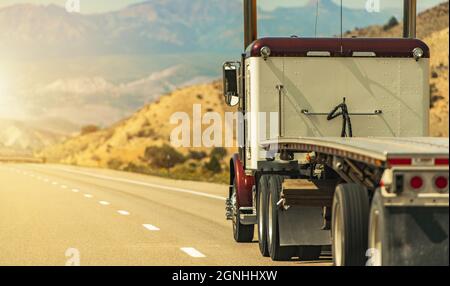 Tema Heavy Duty Freight. Semirimorchio con rimorchio a pianale su una Scenic Utah Interstate 70 Highway. Industria dei trasporti americana. Foto Stock