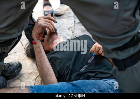 Sheikh Jarach, Israele. 24 settembre 2021. I poliziotti israeliani e i soldati di pattuglia di frontiera dell'IDF arrestano i manifestanti israeliani per aver sventolato le bandiere palestinesi nella protesta di solidarietà settimanale a Sheikh Jarrah. Anche se il ministro della sicurezza interna aveva ordinato alla polizia di fermare la confisca violenta un mese fa, gli ordini non vengono applicati sul campo. Il protestore è stato trattato in un pronto soccorso a causa di lesioni alla testa. Gerusalemme, Israele. 24 settembre 2021. (Foto di Matan Golan/Sipa USA) Credit: Sipa USA/Alamy Live News Foto Stock