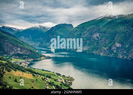 Dalla vista dall'alto del fiordo di Sognefjorden. Grande scena estiva con Aurlandsvangen villaggio, Norvegia. Concetto di viaggio background. Foto Stock