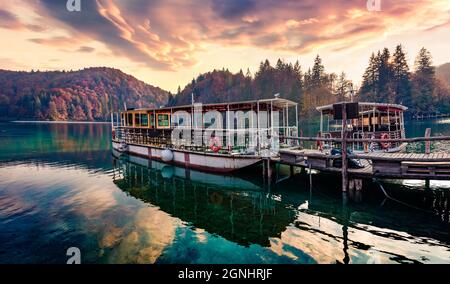 Fantastica vista mattutina del lago d'acqua pura con barche nel Parco Nazionale di Plitvice. Incredibile tramonto autunnale di Croazia, Europa. Bellezza della natura concetto bac Foto Stock