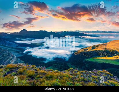 Nebbia scena estiva della catena montuosa di Peitlerkofel. Fantastica alba nelle Alpi dolomitiche. Colorata vista mattutina dai piedi del monte Furchetta, Santa ma Foto Stock