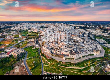 Vista dal drone volante. Splendido paesaggio urbano mattutino della città di Ostuni. Fantastica alba in Puglia, Italia, Europa. Concetto di viaggio background. Foto Stock