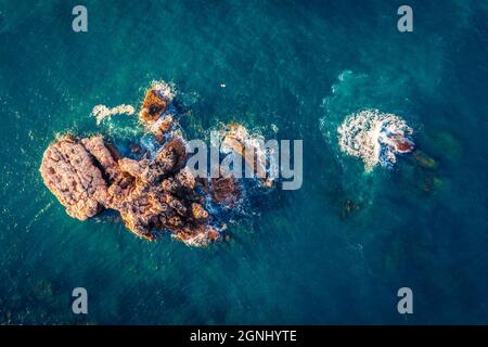 Vista dall'alto delle rocce vulcaniche nel Mediterraneo. Vista dal drone volante della costa della penisola di Milazzo. Splendida scena primaverile della Sicilia, Italia Foto Stock