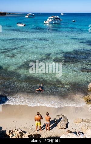 Barche per il tempo libero e turisti alla Laguna Blu sulla costa nord della penisola di Akamas, Cipro. Foto Stock