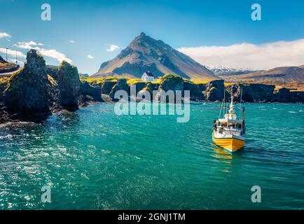 Pittoresca vista mattutina del piccolo villaggio di pescatori ai piedi del Monte Stapafell - Arnarstapi o Stapi. Splendida scena estiva della campagna islandese. Foto Stock