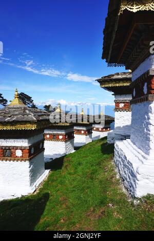 Guardando giù una fila tra alcuni dei 108 Chortens Druk Wangyal identici che si trova al Passo Dochula del Bhutan sulla strada da Thimphu a Punakha. Foto Stock