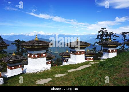 Vista di alcuni dei Chortens Druk Wangyal al Passo Dochula del Bhutan, tra Thimphu e Punakha, con le montagne innevate di Himalaya oltre Foto Stock