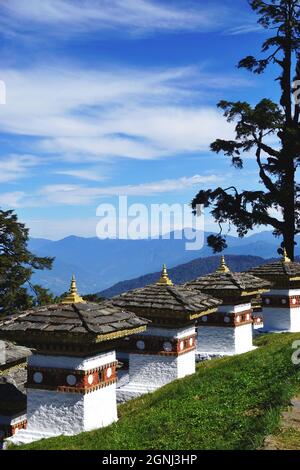 Vista di alcuni dei Chortens Druk Wangyal al Passo Dochula di Bhutan, tra Thimphu e Punakha, con le montagne innevate di Himalaya oltre Foto Stock